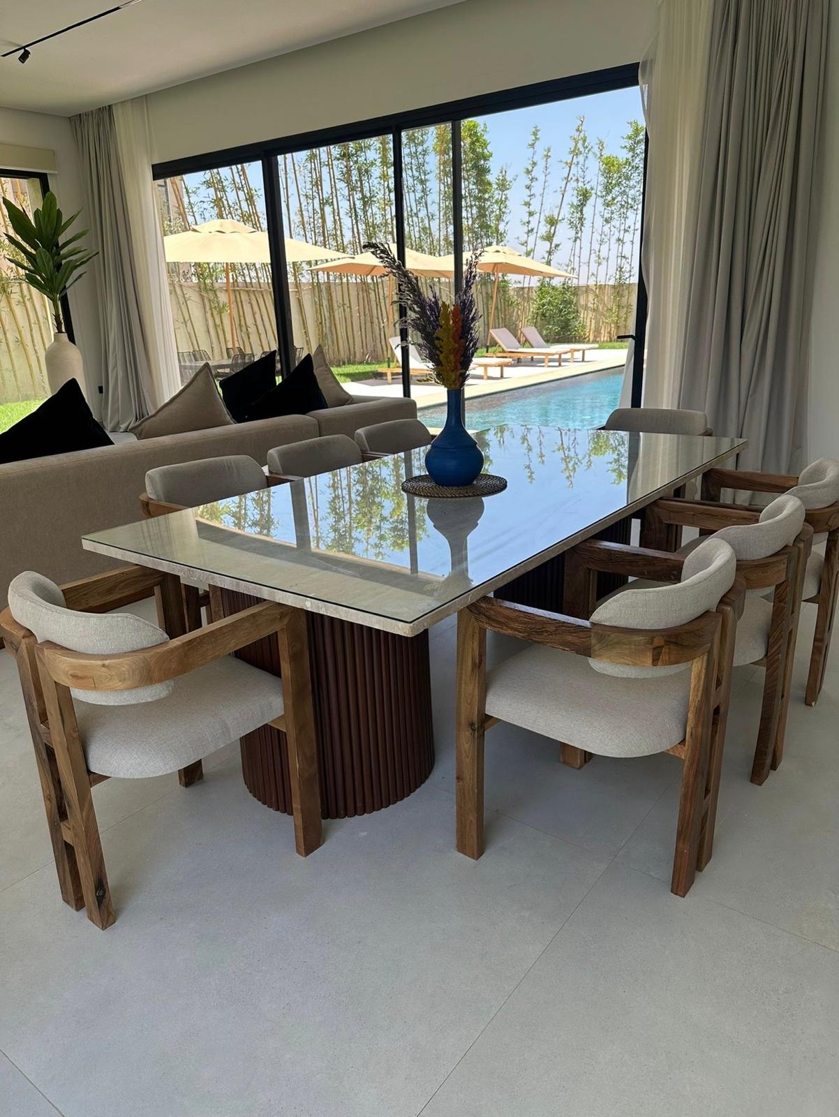 Table basse en travertin SN HOME au bord d'une piscine de villa marocaine